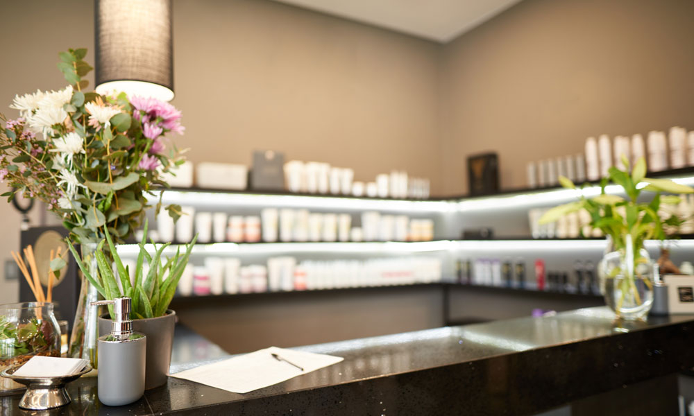 Empfangstresen eines Kosmetikinstituts mit Blumen, Pflanzen und BABOR Pflegeprodukten