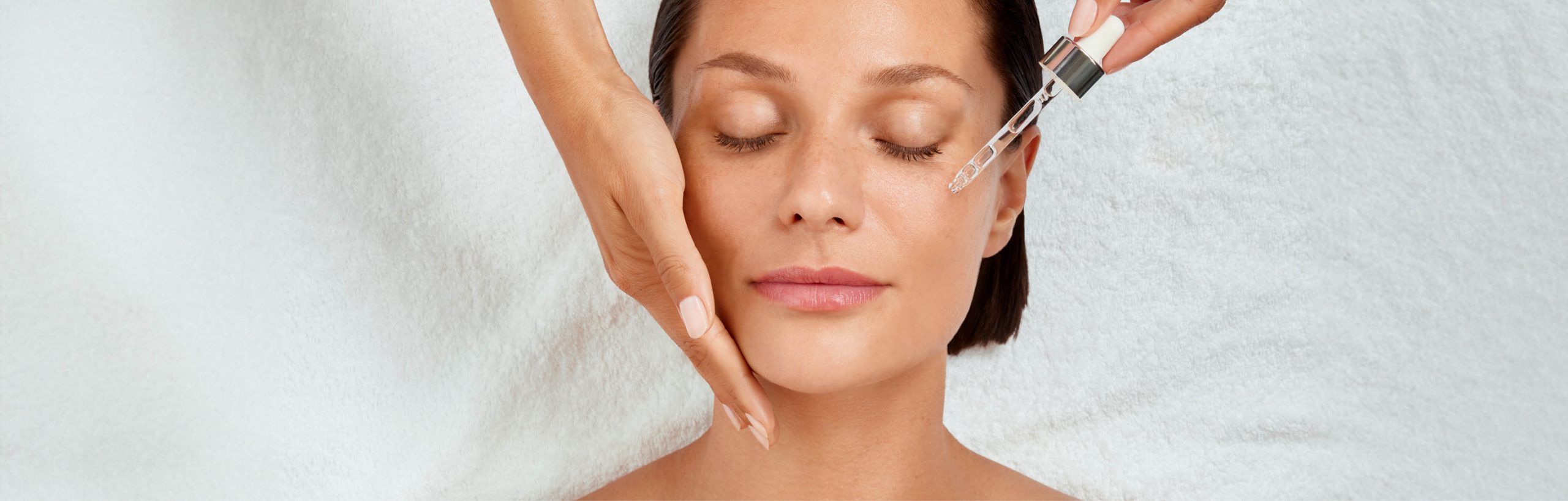 Frau mit geschlossenen Augen, Hand st&uuml;tzt die Wange, Pipette tr&auml;ufelt Serum aufs Gesicht