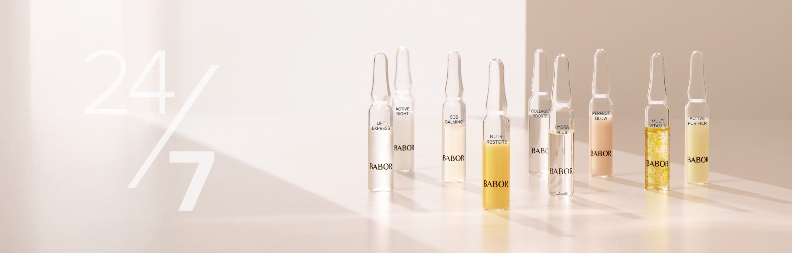 Sieben BABOR Hydra Plus Ampullen stehen auf zwei &uuml;bereinanderliegenden Steinen